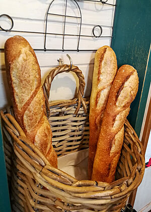 Baguettes meiner letztjährigen Kursteilnehmerin Motomi Nakagawa in ihrer Bäckerei. Baguettes hängen in einem Baguettekorb an der Wand.