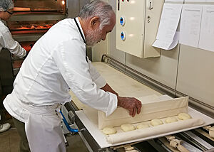 Chef des Hauses, Herr Akashi, beim Backen von Handsemmeln. Der Chef der Bäckerei Brotheim stellt Handsemmeln her.