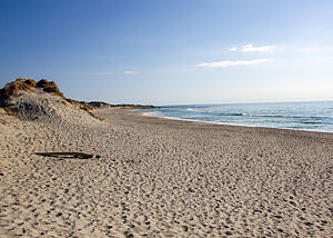 Strand und Sonne. Der Strand ist immer da, aber das Wetter ist meistens durchwachsen. Menschenleerer Strand bei strahlendem Sonnenschein.