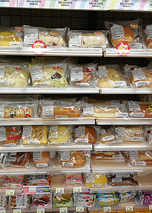 Im Supermarkt-Regal liegen diverse industriell produzierte Kuchen und Brote aus.