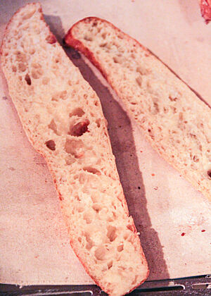 Tolle Porung, auch dank Hemicellulase und Alpha-Amylase, die dem konventionellen T65-Mehl zugesetzt waren. Das aufgeschnittene Baguette zeigt seine elastische, grobporige Krume.