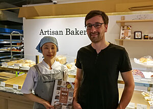 Seine Verkäuferin war früher Kundin bei ihm und verkauft nun selbst die Brote, die sie isst. Besser geht es nicht. Lutz Geißler und eine Verkäuferin stehen im Verkaufsraum der Bäckerei „Artisan Bakery“.