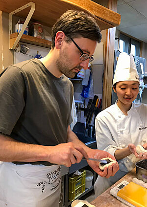 Lutz Geißler und eine japanische Bäckerin füllen Anpans mit Bohnenpaste.