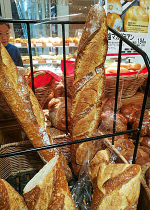 Baguette. Im Verkaufsraum der Bäckerei befindet sich unter anderem ein Baguettekorb mit Baguettes.