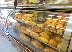 In der Auslage einer kolumbianischen Bäckerei liegen Weizenbrötchen in unterschiedlichen Formen.