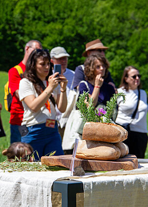 Brotfestteilnehmer stehen um einen Tisch mit Brot herum.