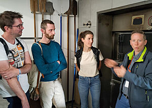 Brotfestteilnehmer und die beiden Bäckerinnen im Gespräch am Holzofen.