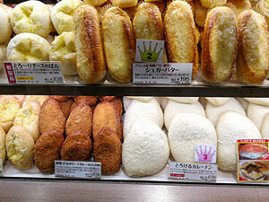 Im Regal einer japanischen Bäckerei liegt paniertes und frittiertes Feingebäck in unterschiedlichen Farben und Formen.