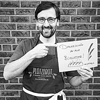 Lutz Geißler hält lächelnd ein Schild hoch, auf dem steht: „Dankeschön an alle Blogleser!“