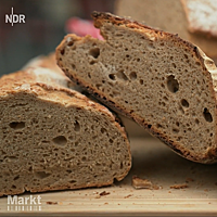Ein halbiertes Roggenmischbrot zeigt im Anschnitt die lockere Krume mit unregelmäßiger Porung.