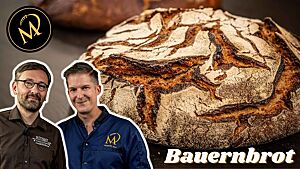 Marcel und ich schauen zufrieden, während hinter uns der runde Laib des rustikalen Bauernbrotes mit der weiß bemehlten, wild aufgerissenen Kruste zu sehen ist.