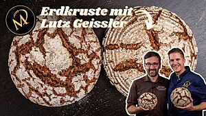 Marcel und ich halten je einen runden Laib des rustikal aufgerissenen Brotes in der Hand.