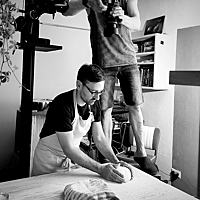 Lutz Geißler wird beim Brotformen von einem Fotografen fotografiert.