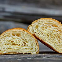 Der Querschnitt der Croissants aus hellem Mehl zeigt die hellgelbe Krume mit der blättrigen und fluffigen Struktur.