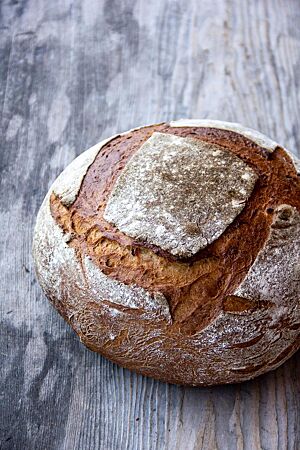 Bananenbrot. Der kräftig ausgebackene Bananenbrotlaib wurde viermal überlappend im Quadrat eingeschnitten.