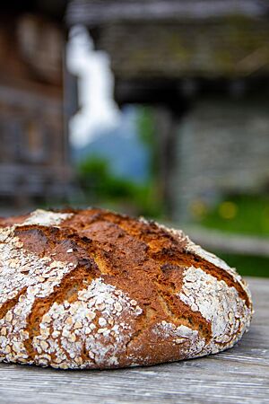 Die kräftig ausgebackene Dinkel-Hafer-Kruste ist mit weißem Mehl und Haferflocken bestreut.