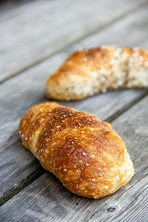 Goldbraun ausgebacken liegen die Dinkelseelen auf einem rustikalen Holztisch.