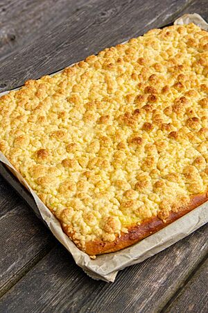 Puddingstreusel mit Zwillingsteig (Dinkelvariante). Ein Puddingstreuselkuchen liegt goldgelb ausgebacken auf einem Backblech.