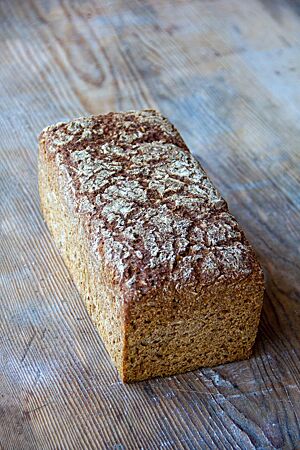 Rheinisches Schwarzbrot. <p>Das kräftig ausgebackene rheinische Schwarzbrot in Form eines Kastenbrotes hat eine leicht bemehlte Kruste mit kleinen Rissen auf der Oberfläche.</p>