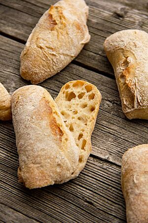Ines’ Kinderbrötchen: lecker und locker. Ein aufgeschnittenes Brötchen zeigt die lockere, elastische Krume umgeben von der hell ausgebackenen Kruste.