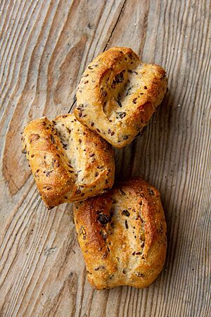 Weiße Brötchen (mit Saaten). Die tief eingeschnittenen Brötchen sind goldbraun ausgebacken.