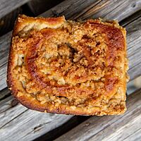 Die mit Streuseln belegte Vollkornpuddingschnecke ist goldbraun ausgebacken.