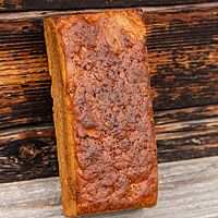 Das als Kastenbrot gebackene Haselnuss-Pflaumen-Brot hat eine glatte, leicht glänzende Oberfläche.