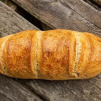 Das hellbraun ausgebackene Ungarische Hausbrot hat eine längliche Form und drei parallele Einschnitte auf der Oberseite.