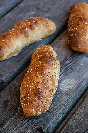 Kartoffelseelen. Die ausgebackenen Kartoffelseelen haben eine glatte Oberfläche, die mit grobem Salz und Kümmel bestreut ist.