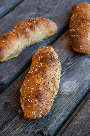 Die ausgebackenen Kartoffelseelen haben eine glatte Oberfläche, die mit grobem Salz und Kümmel bestreut ist.