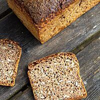 Das aufgeschnittene Brot zeigt eine saftige Krume mit sichtbaren Saaten.