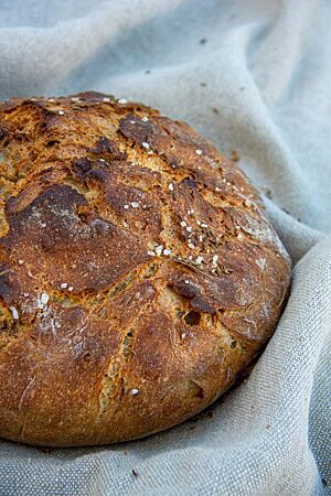 Neudorfer Seelenbrot. Das kräftig ausgebackene Seelenbrot mit Kümmel und Salz auf der Oberfläche liegt auf einem Leinentuch.