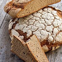 Ein halbierter Laib zeigt die lockere, kleinporige Krume und den relativ flachen Querschnitt des Brotes.