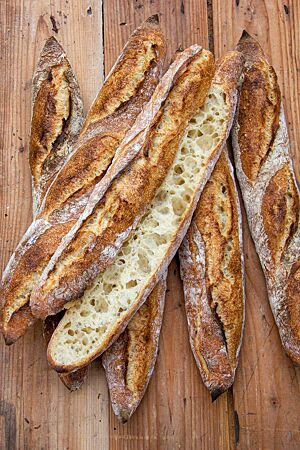 Hüttenbaguette: grobporig und hocharomatisch. Im Anschnitt zeigt das Hüttenbaguette seine helle, grobporige Krume im Kontrast zur dunklen Kruste mit rustikalem Ausbund.