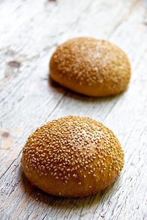 Vegane Burger Buns. Die goldbraun ausgebackenen Burger Buns sind auf der Oberfläche mit Sesam bestreut.