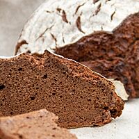 Das Schokoladenbrot aus dem ersten Backversuch erscheint im Brotquerschnitt etwas gedrungen, kleinporig und fest.