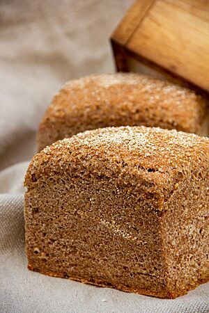 Weizenschrotbrot. Die im Backrahmen gebackenen Weizenschrotbrote haben eine glatte, braun gefärbte Kruste.