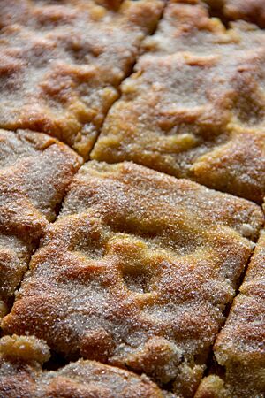 Der flache, goldgelb ausgebackene Kartoffelkuchen mit Zimtzucker auf der Oberfläche wurde in rechteckige Stücke geschnitten