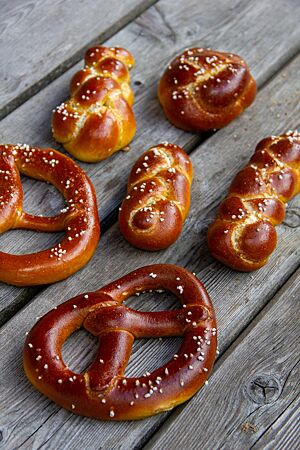 Zwei Brezeln, ein Knoten und drei kleine Zöpfe sind auf ihrer dunkelbraunen Kruste mit weißen Salzkörnern bestreut.