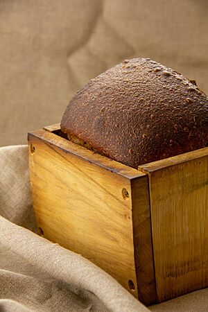 Das dunkelbraune Honig-Salz-Brot wurde in einem Backrahmen gebacken und zeigt eine glatte, leicht glänzende Kruste.