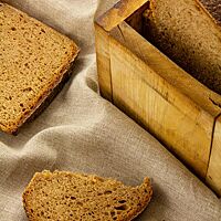 Das Honig-Salz-Brot zeigt im Anschnitt die kleinporige, honigkuchenfarbene Krume umgeben von der dünnen, dunkelbraun ausgebackenen Kruste.