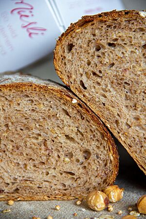 Angeschnitten zeigt das Müslibrot die Müslianteile in der lockeren Krume.