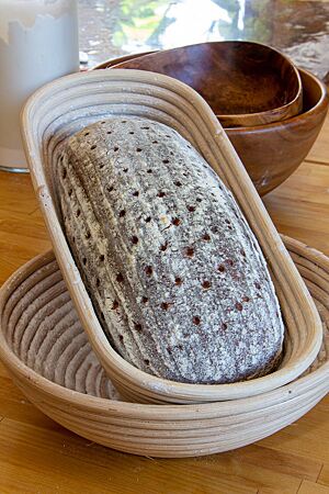 Nußdorfer Landbrot. Das kräftig ausgebackene Nußdorfer Landbrot liegt in einem länglichen Gärkorb aus Peddigrohr.