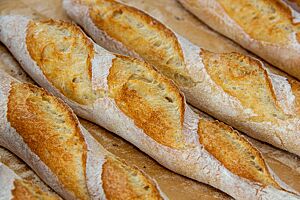 Baguettes (2012). Die goldbraun ausgebackenen Baguettes mit leicht bemehlter Oberfläche sind rustikal aufgerissen.