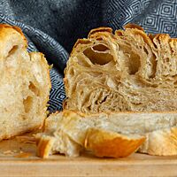 Im Anschnitt des Croissant-Brotes werden die einzelnen Teigschichten und die sehr elastische Krume sichtbar.