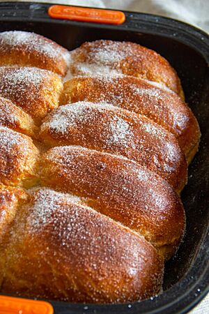 Dresdener Buchteln. Die mit Butter, Zucker und Zimt bestreuten Buchteln sind goldbraun ausgebacken.