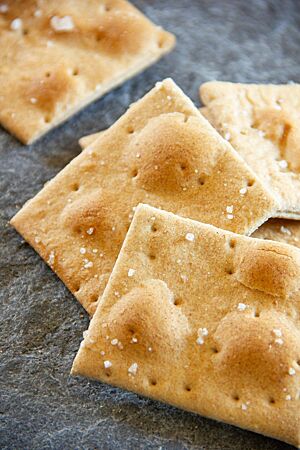 Schwedisches Knäckebrot. Das goldgelb ausgebackene Knäckebrot ist zu kleinen Rechtecken geschnitten, gestippt und mit Fleur de Sel bestreut.