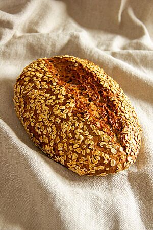 Weinheimer Möhrenbrot. Das tief eingeschnittene Weinheimer Möhrenbrot mit Haferflocken auf der Kruste liegt auf einem Leinentuch.