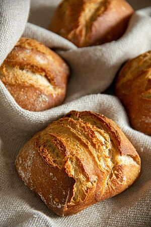 Buttermilchbrötchen. Die doppelt aufgerissenen, sehr rustikalen Brötchen haben eine rösche hellbraune Kruste.