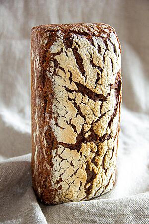 Das im Kasten gebackene Roggenbrot hat eine kräftig ausgebackene, stark bemehlte Kruste mit Rissen auf der Oberfläche.